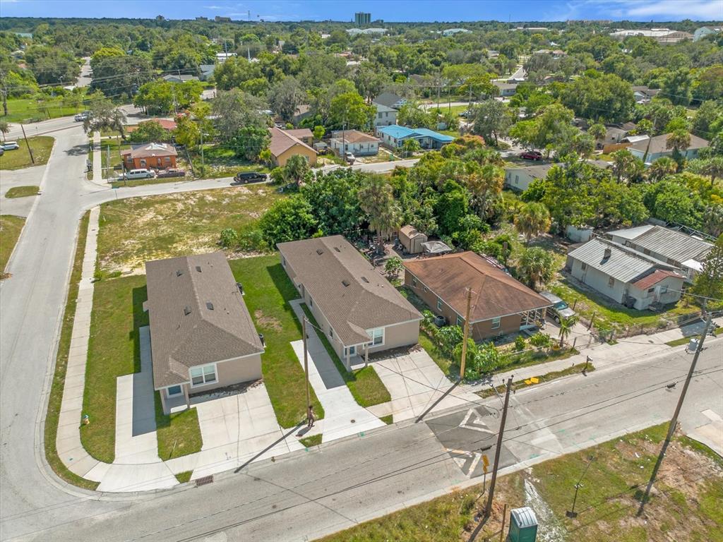 An aerial view shows three houses with driveways situated along a residential street — 324 AVENUE Y NE UNIT B, WINTER HAVEN, FL