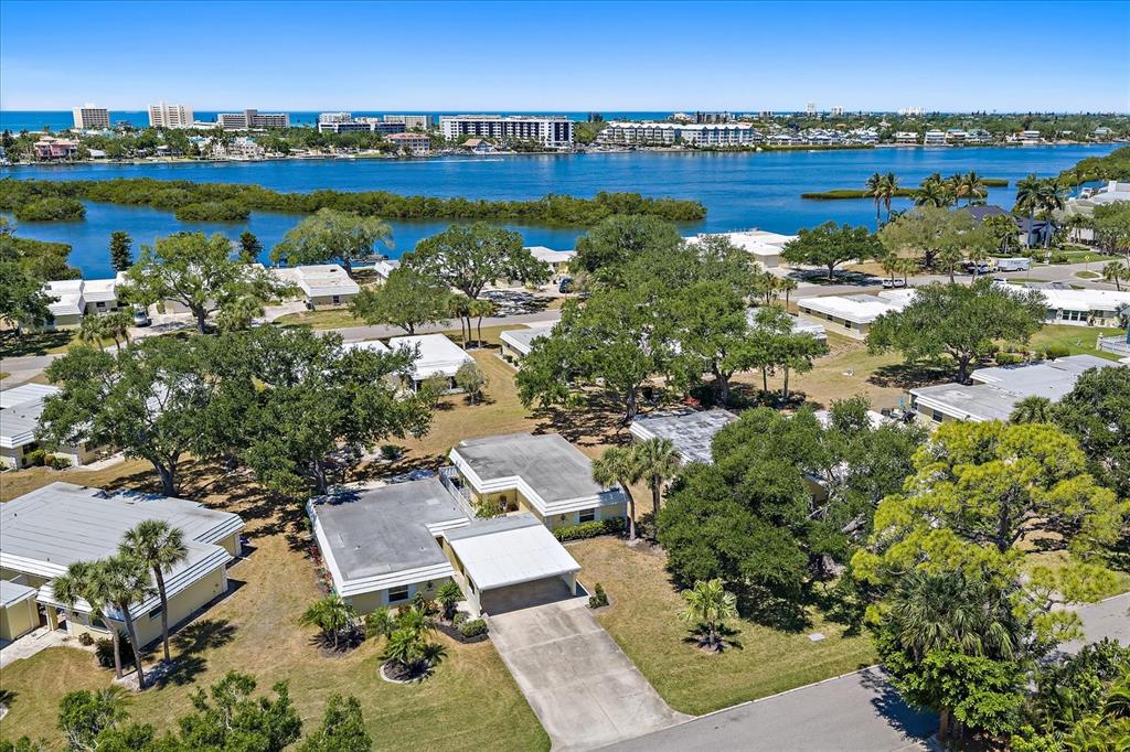 An aerial view shows a single-story house with a carport surrounded by trees and grass — 5940 DRIFTWOOD AVENUE UNIT 15, SARASOTA, FL