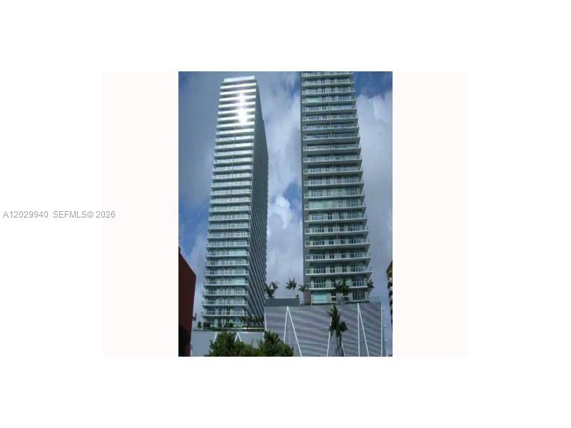Two tall, modern residential towers rise above a multi-level parking podium — 1111 SW 1 AV, Miami FL 33130, MIAMI, FL