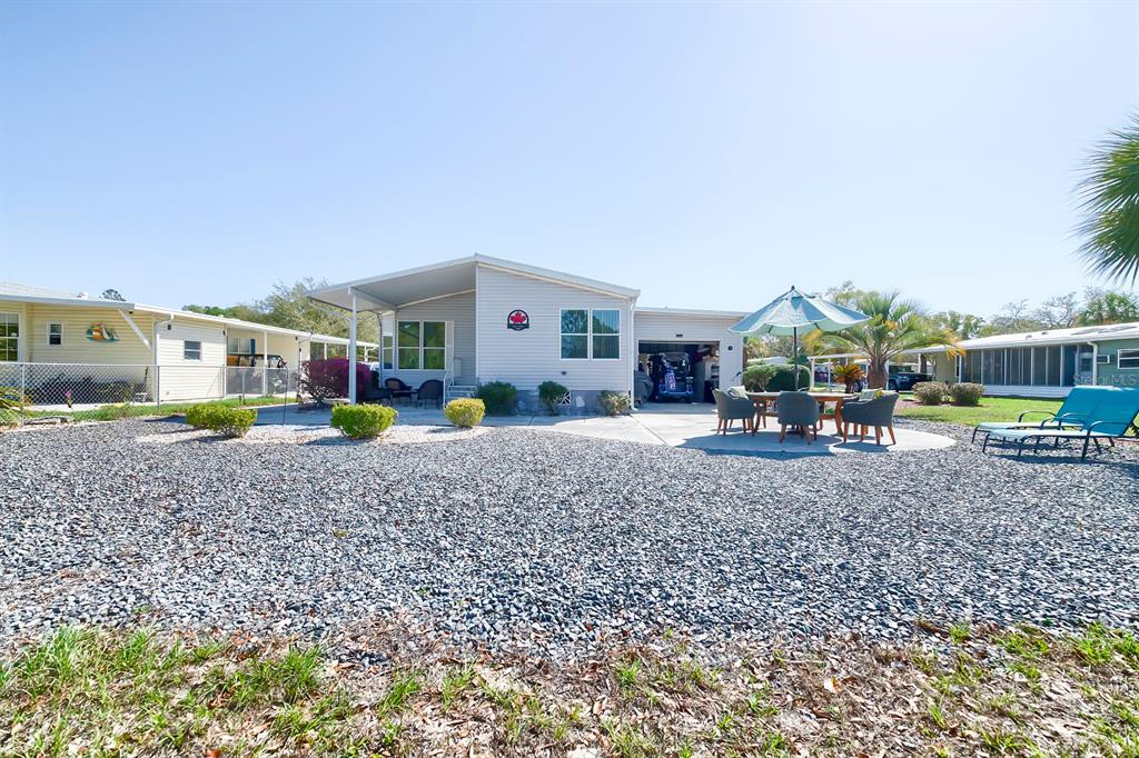 A single-story house with a gravel yard, patio furniture, and an attached garage — 15025 BROOKRIDGE BOULEVARD, BROOKSVILLE, FL