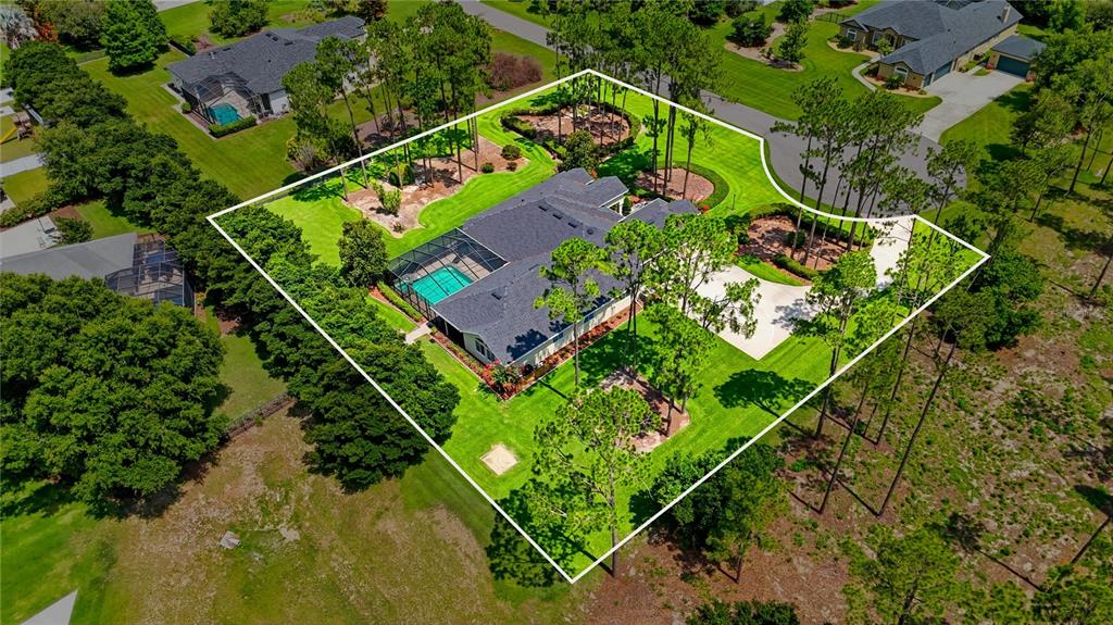 An aerial view shows a house with a pool and large yard outlined in white — 140 SYLVANA COURT, AUBURNDALE, FL