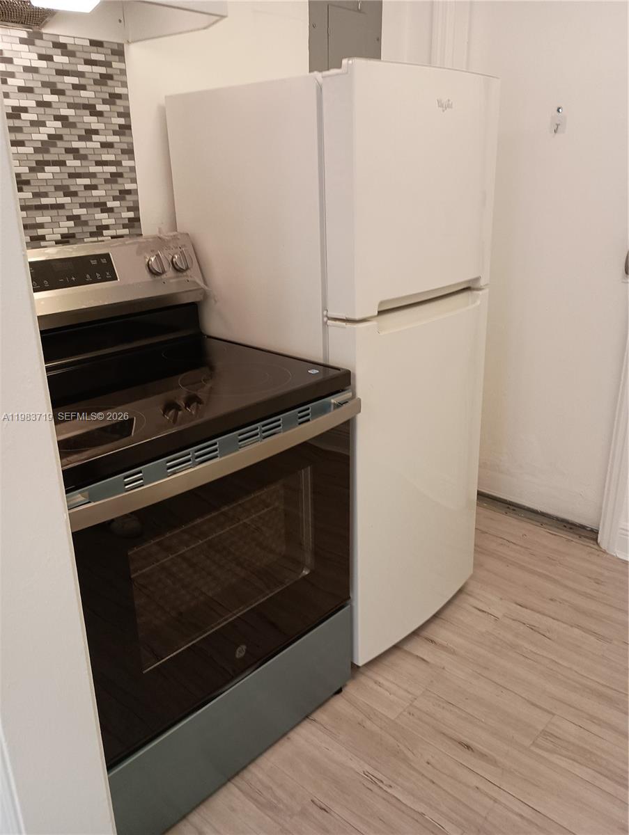 A kitchen features a stainless steel electric stove next to a white top-freezer refrigerator — 535 74 # 7, Miami Beach FL 33141, MIAMI BEACH, FL