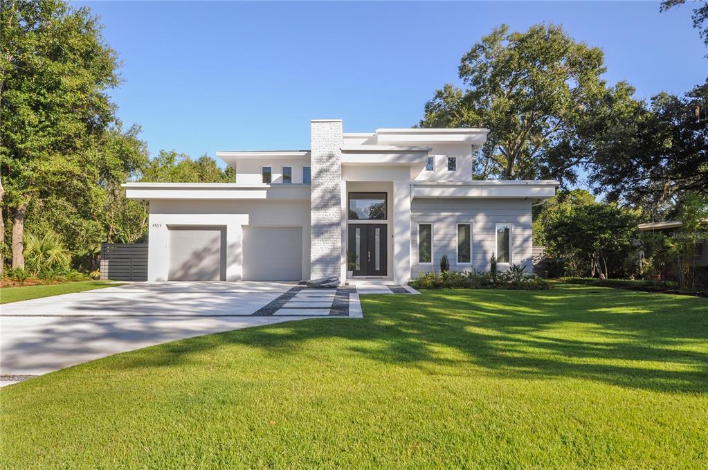 A modern white house with a flat roof, stone chimney, and a paved driveway — 1130 MECHANIC STREET, MAITLAND, FL