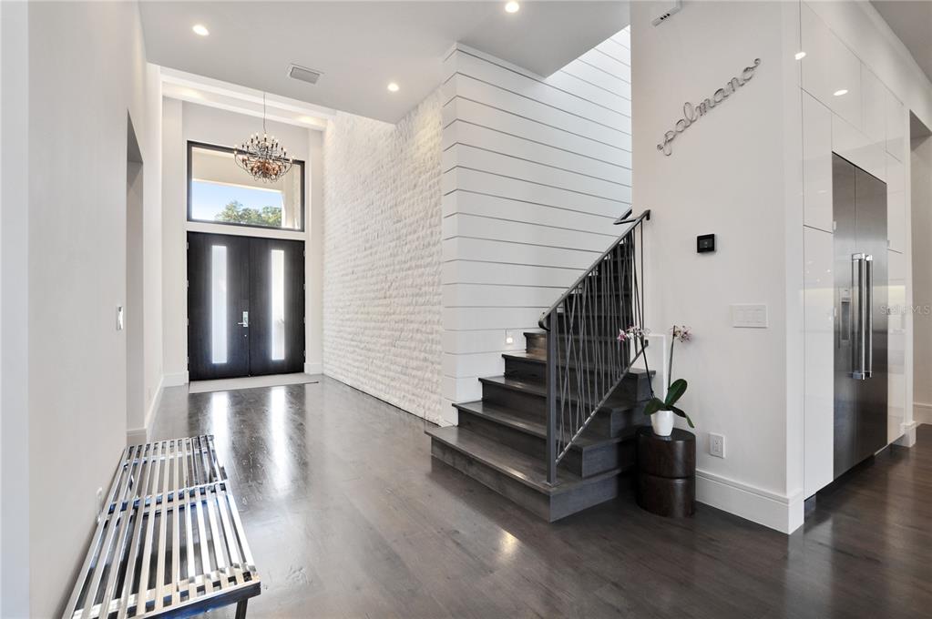 A modern foyer features dark wood floors, a white shiplap wall, and a staircase — 1130 MECHANIC STREET, MAITLAND, FL