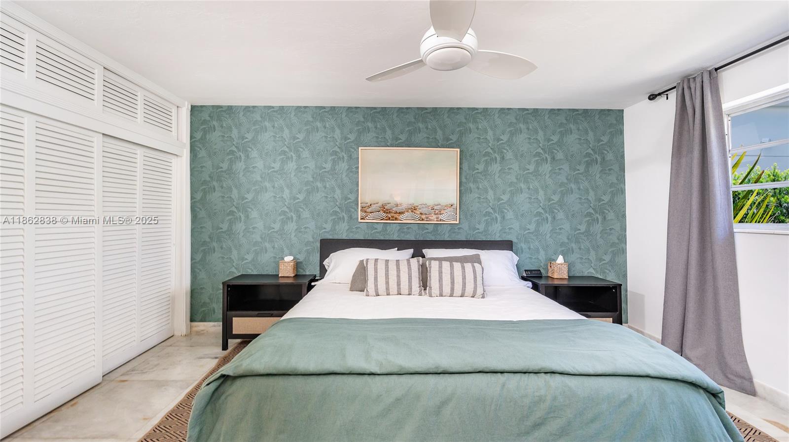 A bedroom features a teal patterned accent wall, a bed with striped pillows, and white shutters — 195 Sunrise Dr # 1, Key Biscayne FL 33149, KEY BISCAYNE, FL