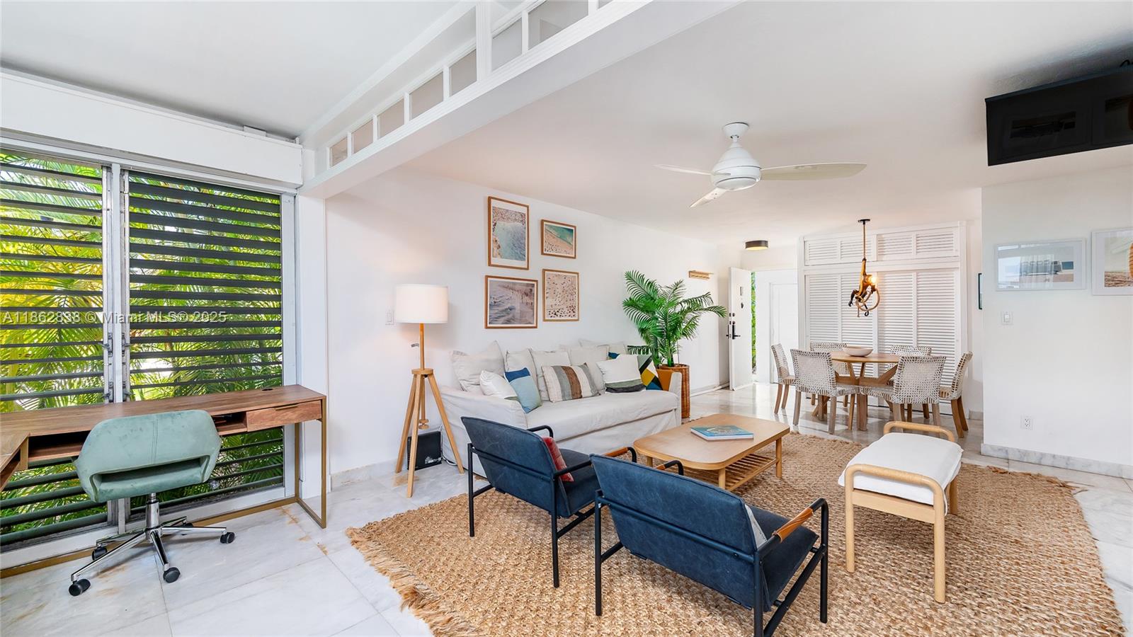 A bright living and dining area features white walls, marble floors, and a wooden desk — 195 Sunrise Dr # 1, Key Biscayne FL 33149, KEY BISCAYNE, FL