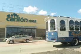 A beige sedan is parked in front of the El Cantón Mall near a trolley — 167 PR 167 INT. BETANCES ST., BAYAMON, PR