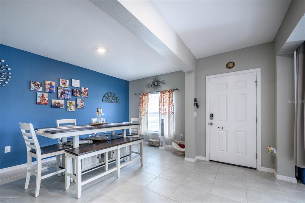A dining area features a blue accent wall, a white table with benches, and a door — 25506 DOREDO DRIVE, PUNTA GORDA, FL