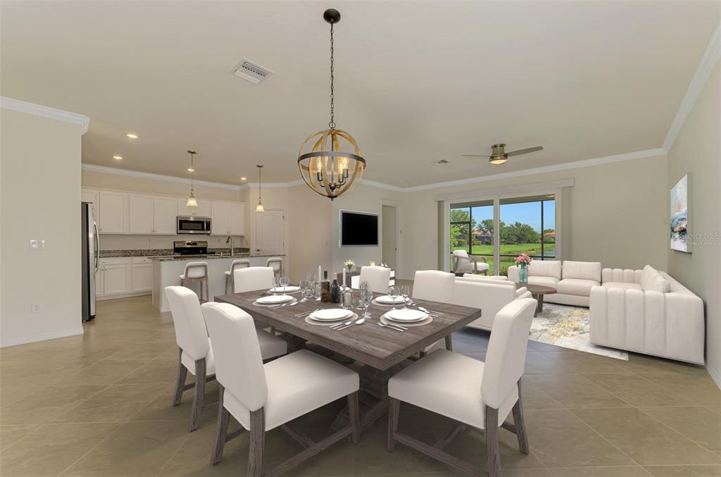 A dining area with a wooden table and white chairs opens to a modern kitchen — 9824 HILLTOP DRIVE, VENICE, FL