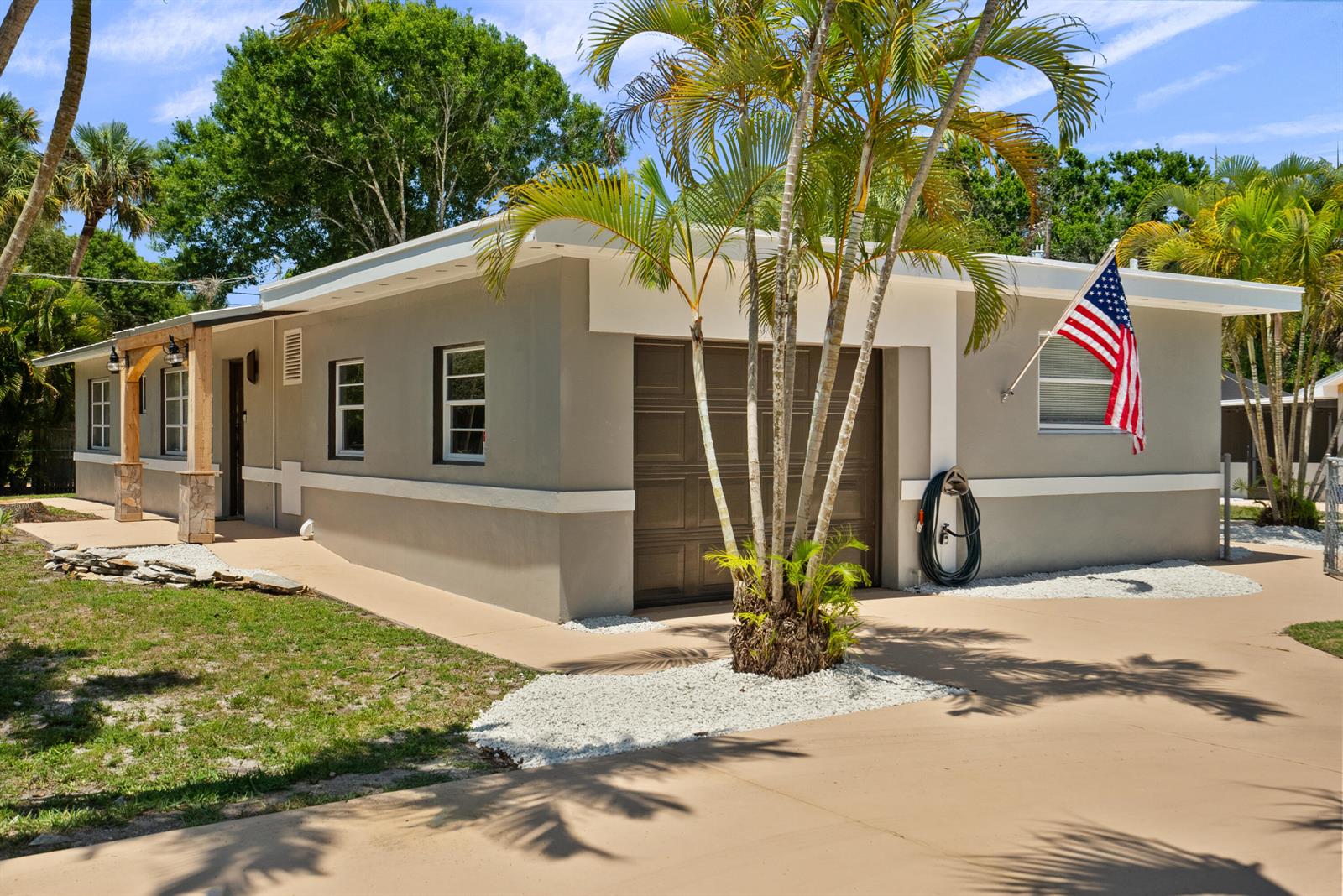 A single-story house with a tan exterior, a garage, and palm trees in the front yard — 4220 Sunrise Boulevard, Fort Pierce FL 34982, FORT PIERCE, FL