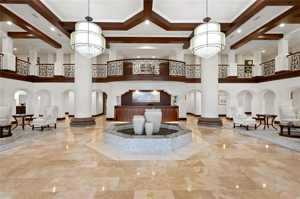 A grand lobby features a central tiered fountain, marble floors, and a mezzanine balcony — 4201 BAYSHORE BOULEVARD UNIT 2101, TAMPA, FL