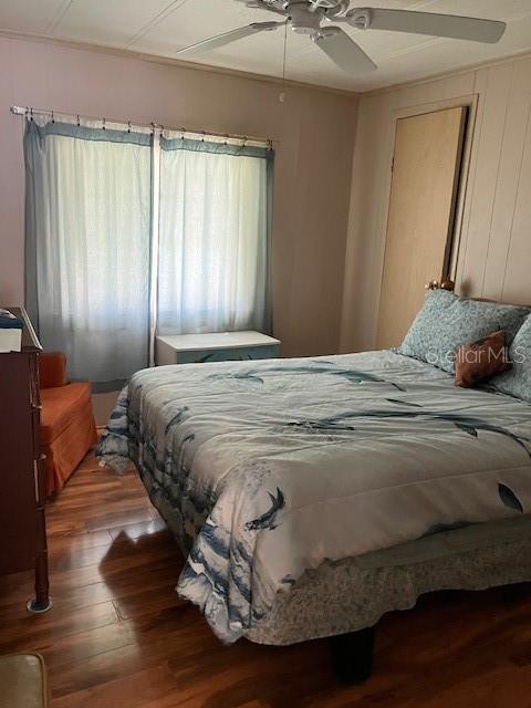 A bedroom features a bed with a patterned quilt, wood-look flooring, and a ceiling fan — 3201 BREWSTER DRIVE, HOLIDAY, FL