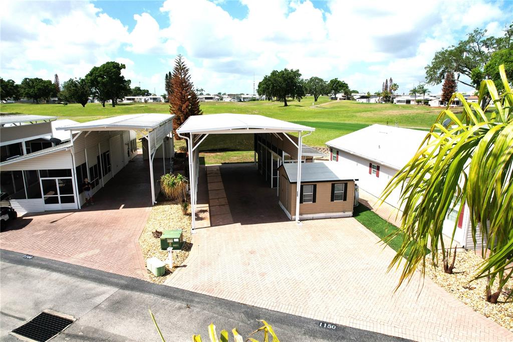An elevated view shows two adjacent manufactured homes with covered carports and a small shed — 1150 DEER CREEK BOULEVARD, DAVENPORT, FL