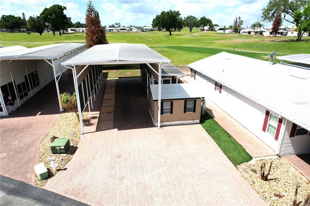 An elevated view shows a paved driveway with a carport between two residential buildings — 1150 DEER CREEK BOULEVARD, DAVENPORT, FL