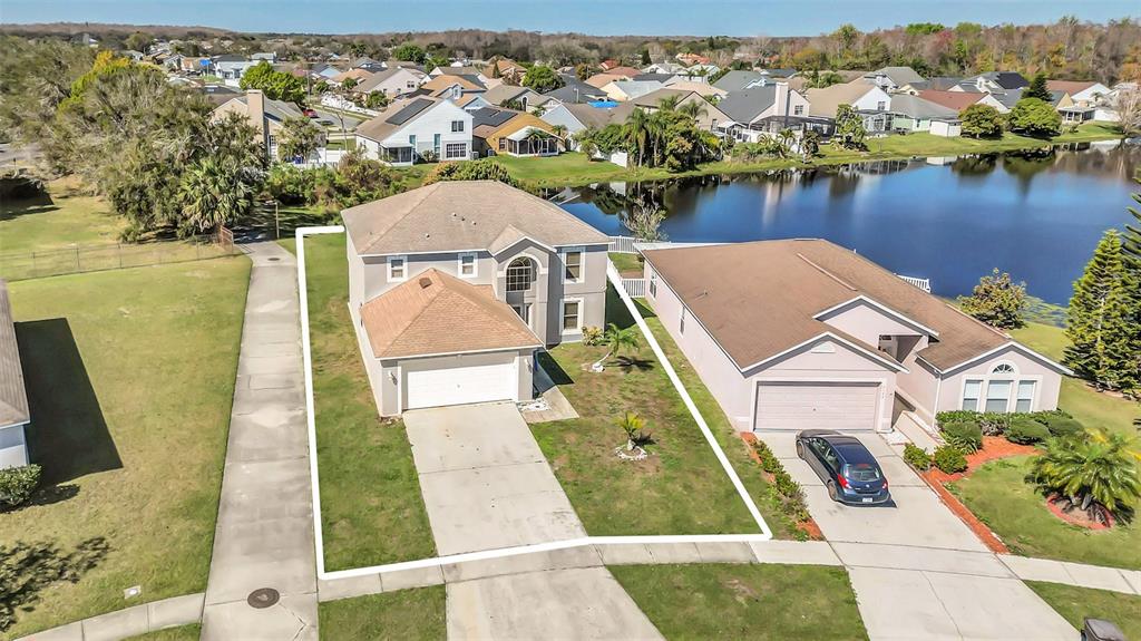 An aerial view shows a two-story suburban house with a white outline marking its lot — 2120 MARISOL LOOP, KISSIMMEE, FL
