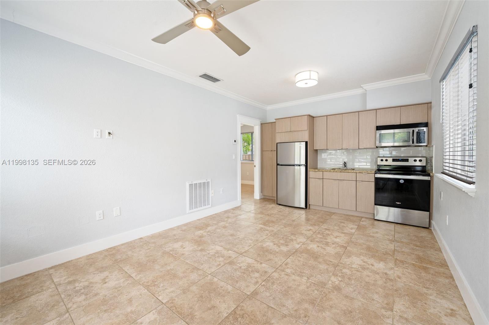 A kitchen with light wood cabinets, stainless steel appliances, and beige tile flooring — 4 Transylvania Ave # B, Key Largo FL 33037, KEY LARGO, FL