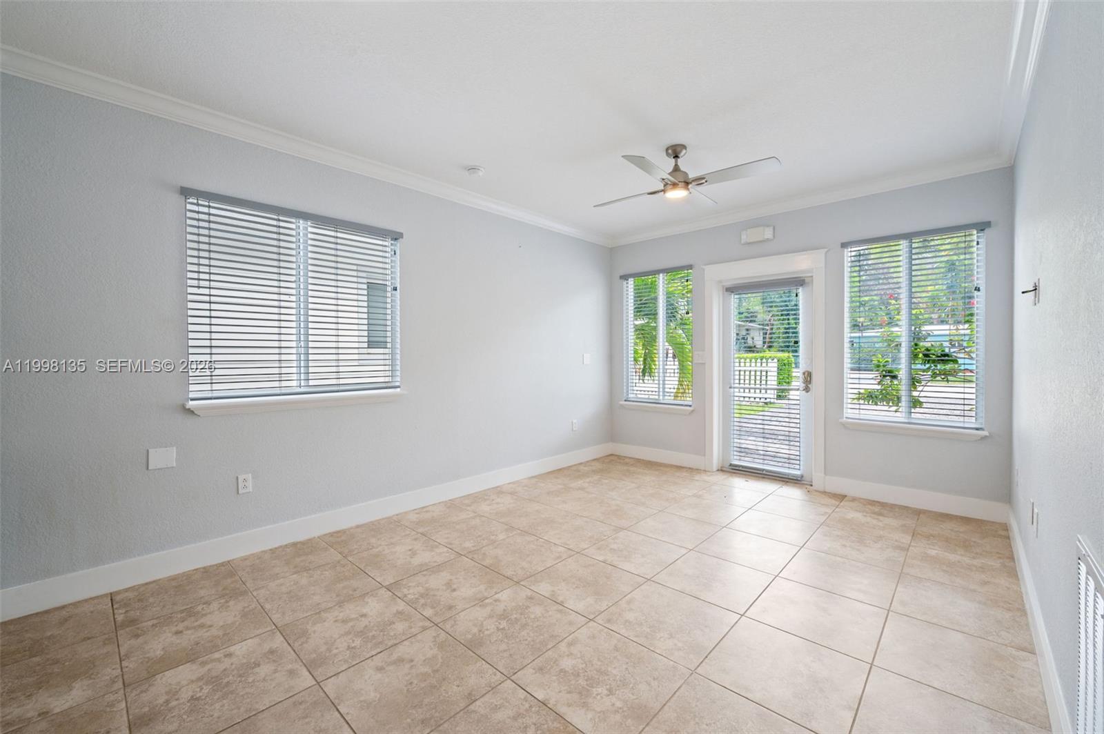 An empty room features light-colored walls, tile flooring, a ceiling fan, and multiple windows — 4 Transylvania Ave # B, Key Largo FL 33037, KEY LARGO, FL