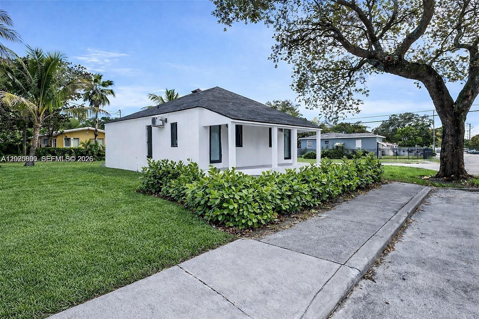 A white, single-story house with a dark roof and a hedge-lined front porch — 6901 NW 4th Ct # A, Miami FL 33150, MIAMI, FL