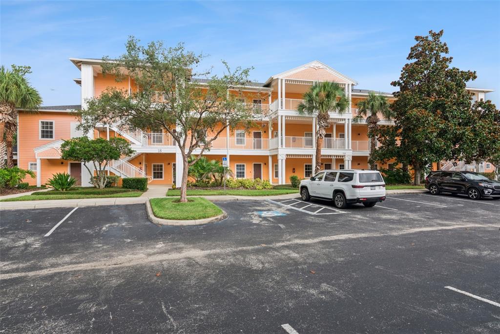 A three-story orange apartment building with exterior staircases and a parking lot in front — 708 NEW PROVIDENCE PROMENADE, DAVENPORT, FL