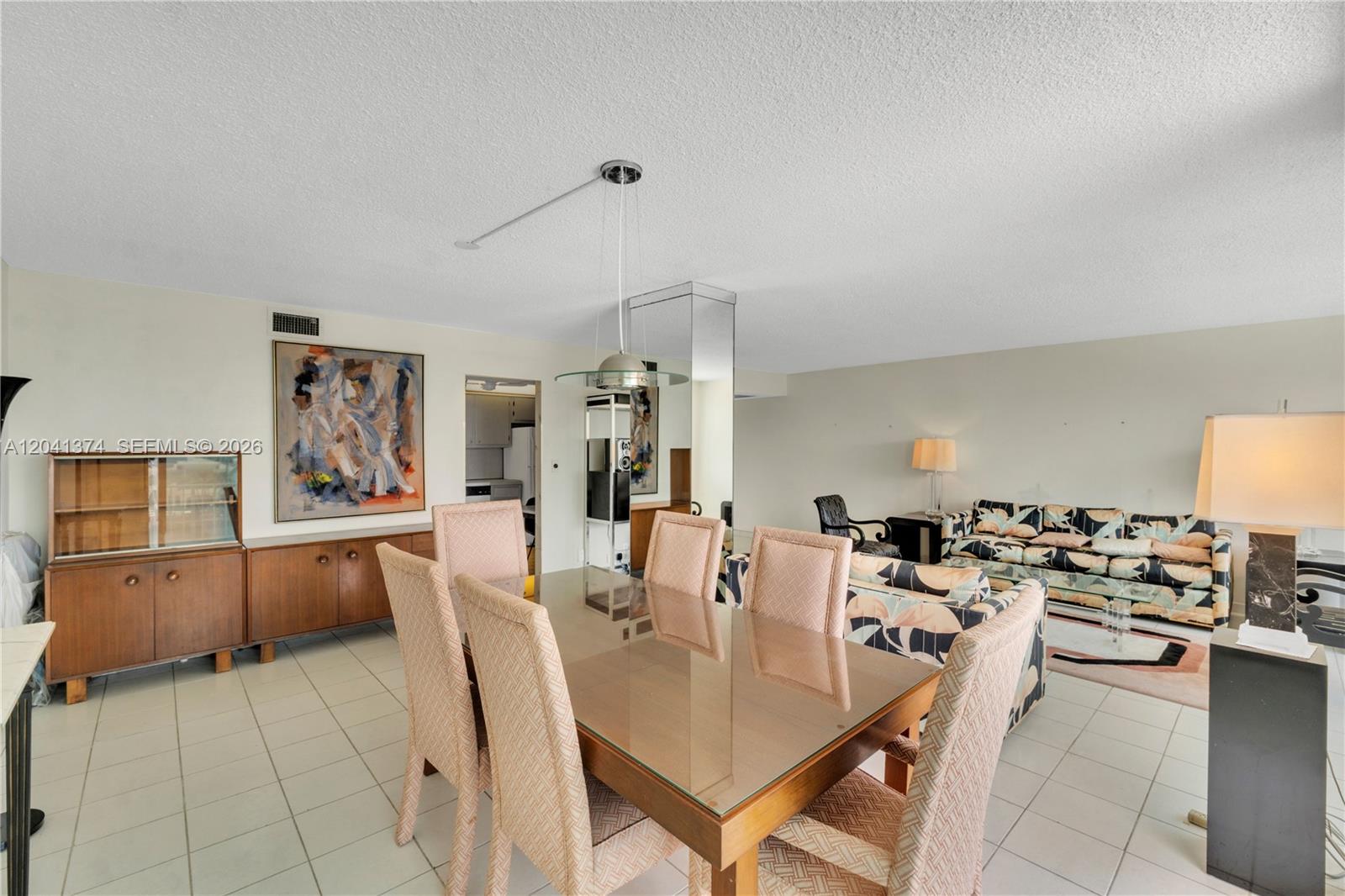 A dining area with a glass-topped table and chairs sits adjacent to a living room — 1410 S Ocean Dr # 304, Hollywood FL 33019, HOLLYWOOD, FL