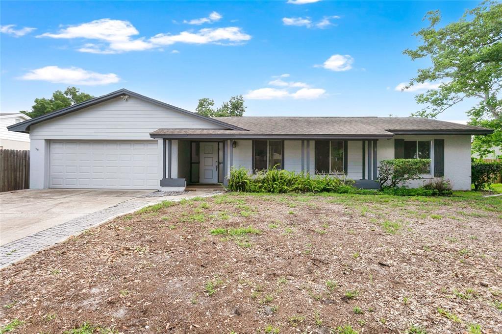 A single-story house with a gray exterior, a two-car garage, and a large front yard — 8644 SANDBERRY BOULEVARD, ORLANDO, FL