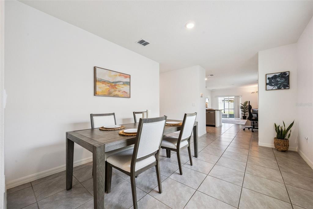 A dining area features a wooden table with four chairs on a tiled floor — 3624 SUNGROVE CIRCLE, SANFORD, FL