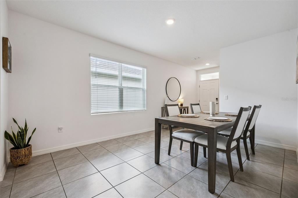 A dining room with tile flooring, a wooden table, four chairs, and a window — 3624 SUNGROVE CIRCLE, SANFORD, FL