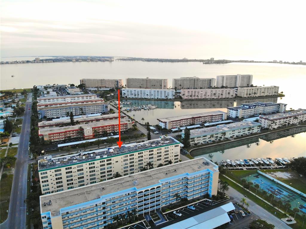 An aerial view shows multiple multi-story apartment buildings surrounding a marina and a large bay — 2960 S 59TH STREET UNIT 311, GULFPORT, FL