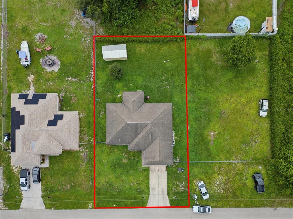 An aerial view shows a house with a gray roof centered on a rectangular lot — 3109 64TH STREET W, LEHIGH ACRES, FL