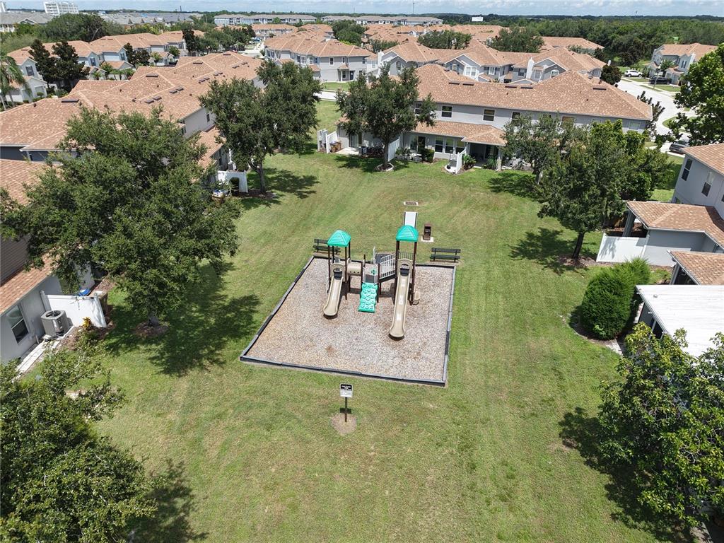 The exterior of a two-story stucco house features a large tree and a side lawn — 2510 HASSONITE STREET, KISSIMMEE, FL