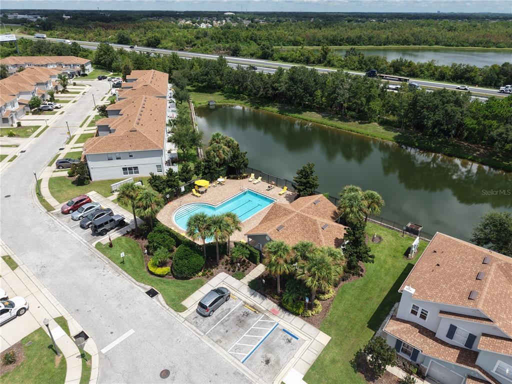 The exterior of a two-story house features a concrete patio, sliding glass doors, and umbrella — 2510 HASSONITE STREET, KISSIMMEE, FL