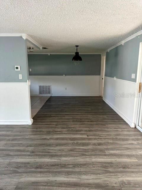 A room with gray and white walls, wood-look flooring, and a hanging pendant light — 10840 NORWOOD AVENUE, PORT RICHEY, FL
