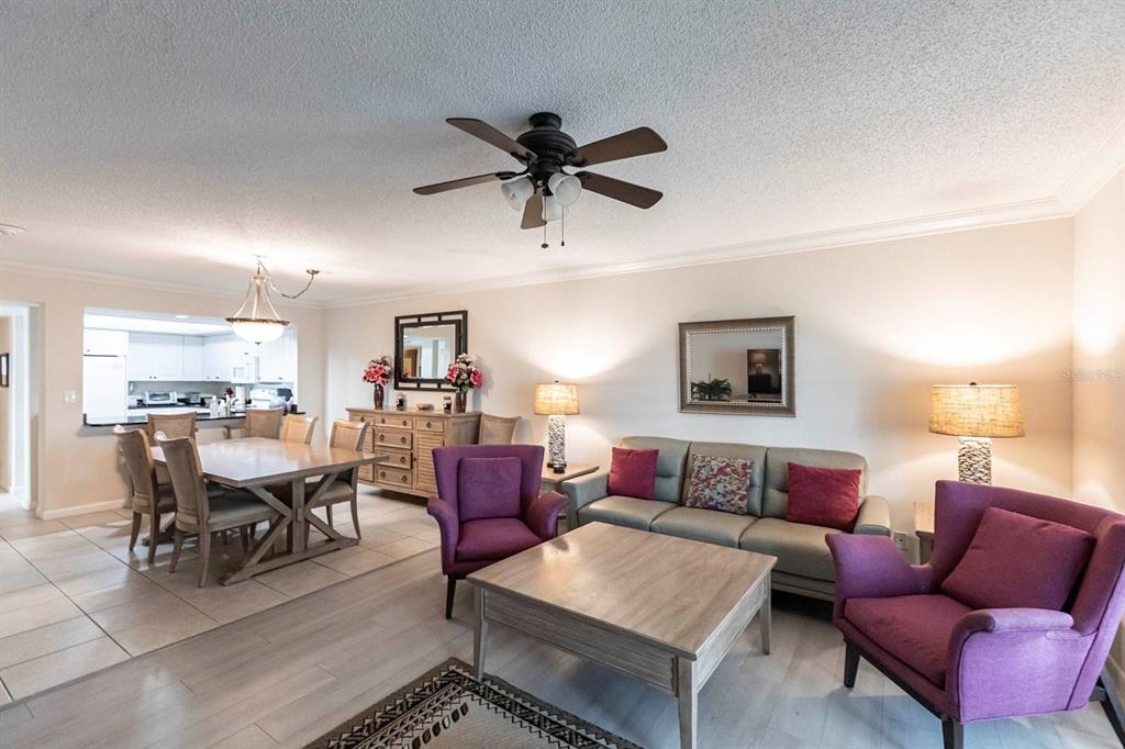 A living and dining area features light tile flooring, purple armchairs, and a gray sofa — 1125 W PEPPERTREE DRIVE UNIT 707, SARASOTA, FL