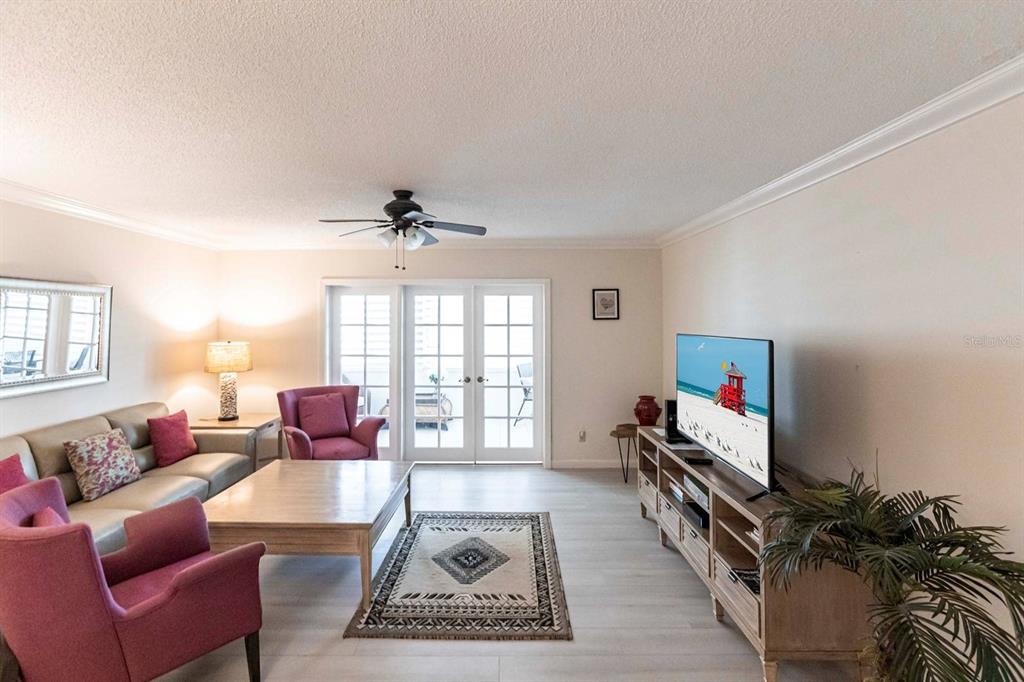 A living room features a sofa, two armchairs, a coffee table, and a television console — 1125 W PEPPERTREE DRIVE UNIT 707, SARASOTA, FL