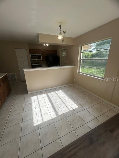 A kitchen with a breakfast bar and tile flooring opens into a dining area — 222 ALBERT STREET, WINTER SPRINGS, FL
