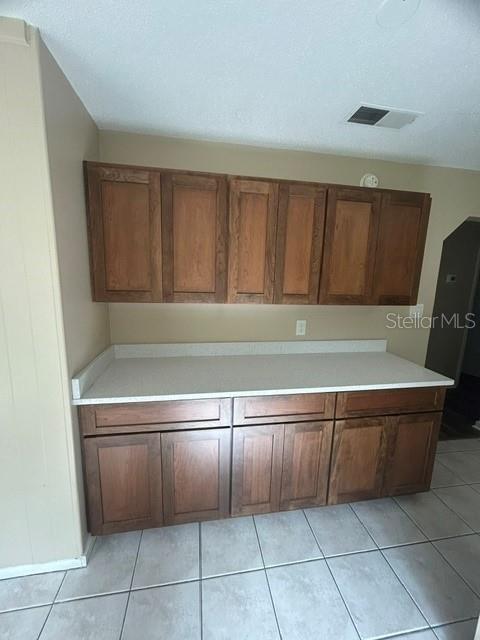 A kitchen area features wooden cabinets, a white countertop, and light-colored floor tiles — 222 ALBERT STREET, WINTER SPRINGS, FL