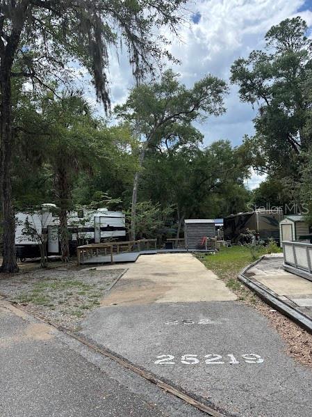 A paved lot with the number 25219 features a parked RV and a small shed — 25219 141ST LANE NE UNIT 252, FORT MC COY, FL