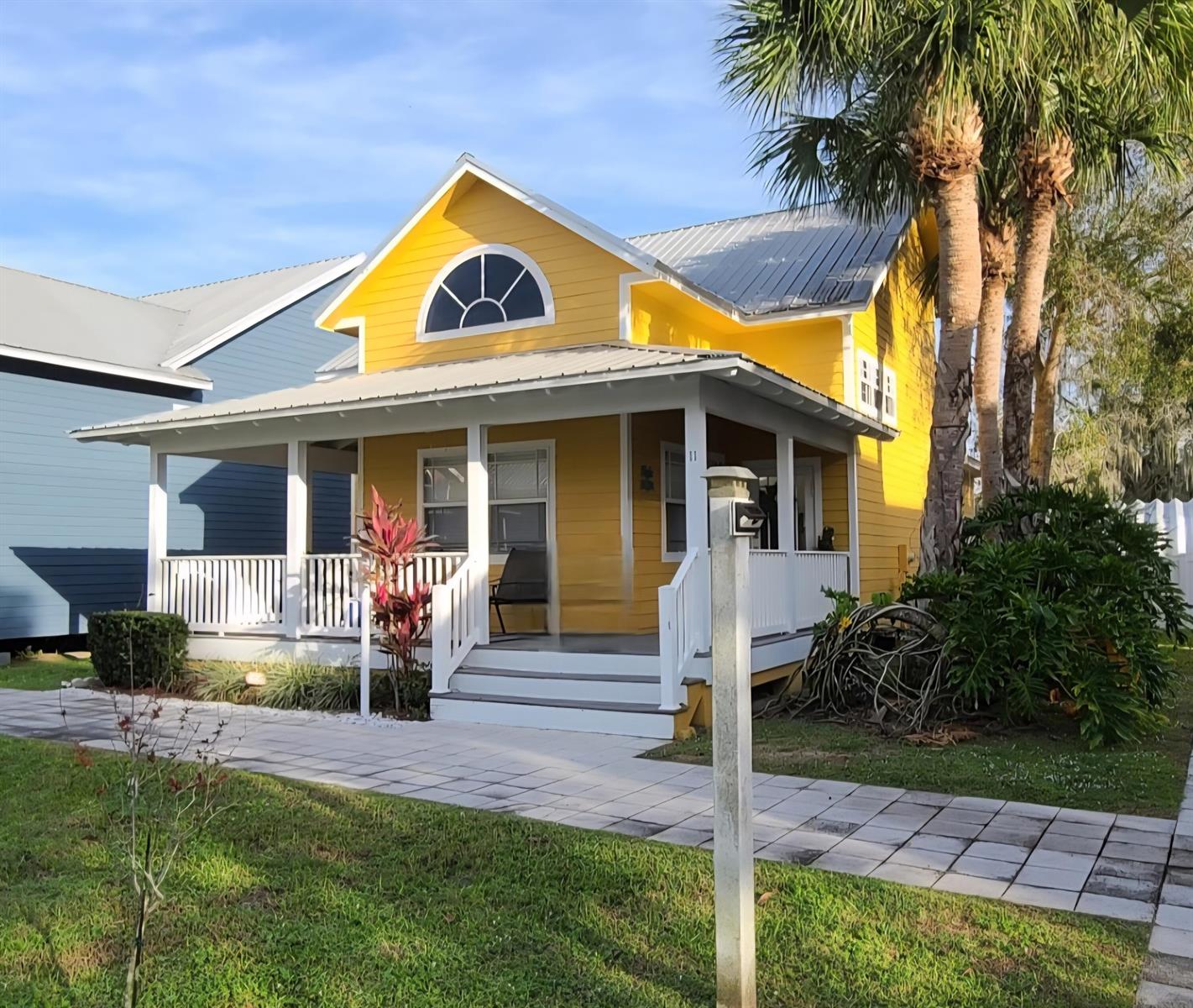 A bright yellow house with a metal roof and a front porch sits on grass — 4334 SE Us Highway 441 # 11, Okeechobee FL 34974, OKEECHOBEE, FL