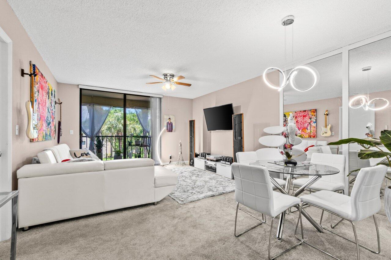 A living and dining area features a white sectional sofa, glass table, and mirrored wall — 5100 Las Verdes Circle # 316, Delray Beach FL 33484, DELRAY BEACH, FL