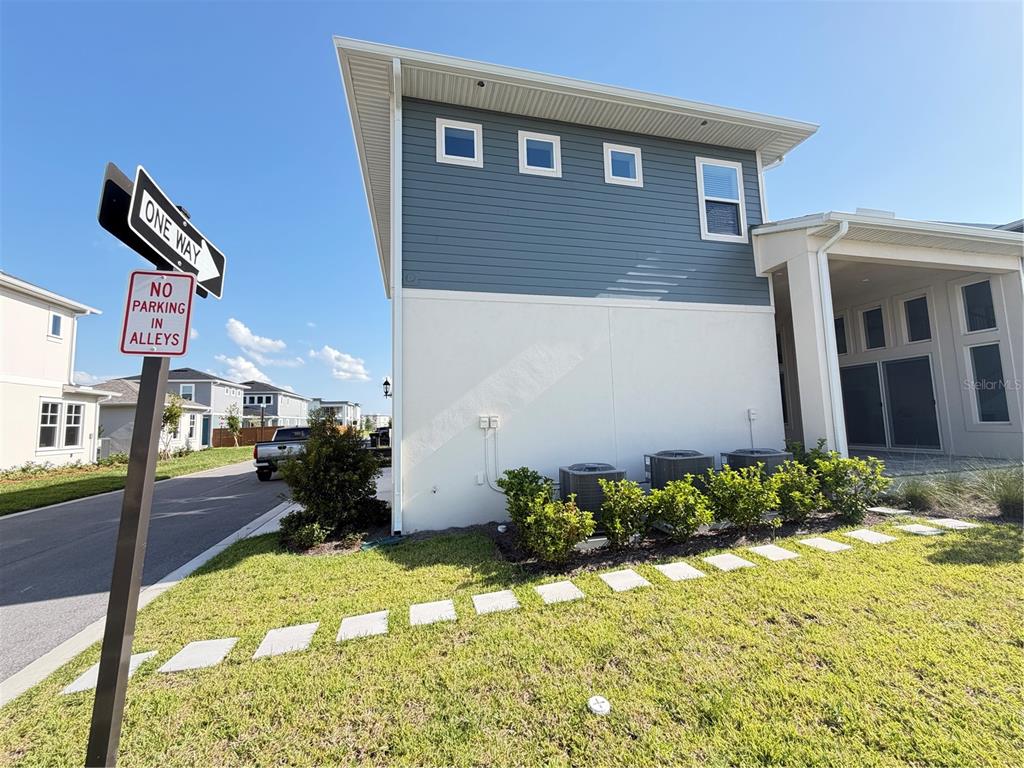 The exterior of a two-story house features blue siding, white stucco, and three air conditioning units — 10108 FIDDLEY ALY, ORLANDO, FL