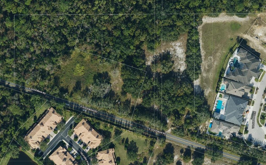 An aerial map shows a wooded plot of land bordered by a road and houses — 1345 S GOODMAN ROAD, CHAMPIONS GATE, FL