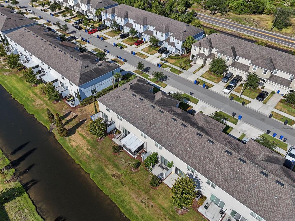 An aerial view shows a row of townhouses with a canal running alongside them — 7052 SUMMER HOLLY PLACE, RIVERVIEW, FL