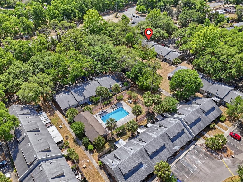 An aerial view shows a residential complex with multiple buildings, a swimming pool, and trees — 3426 NW 37TH AVENUE UNIT 3426, GAINESVILLE, FL