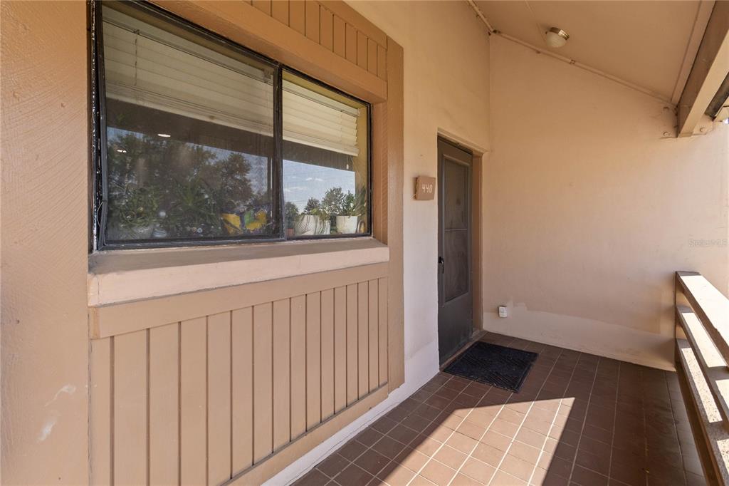 A covered outdoor entryway features a tiled floor, a window, and a door labeled 440 — 440 ORIENTA POINT STREET, ALTAMONTE SPRINGS, FL