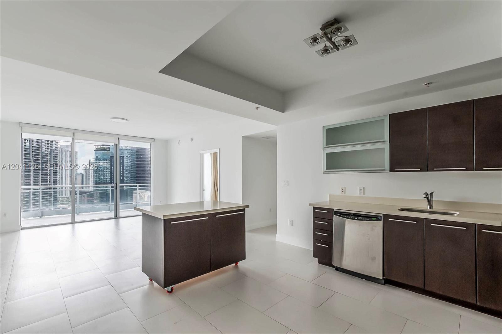 A modern kitchen features dark wood cabinets, stainless steel appliances, and a portable island — 90 SW 3rd St # 3211, Miami FL 33130, MIAMI, FL