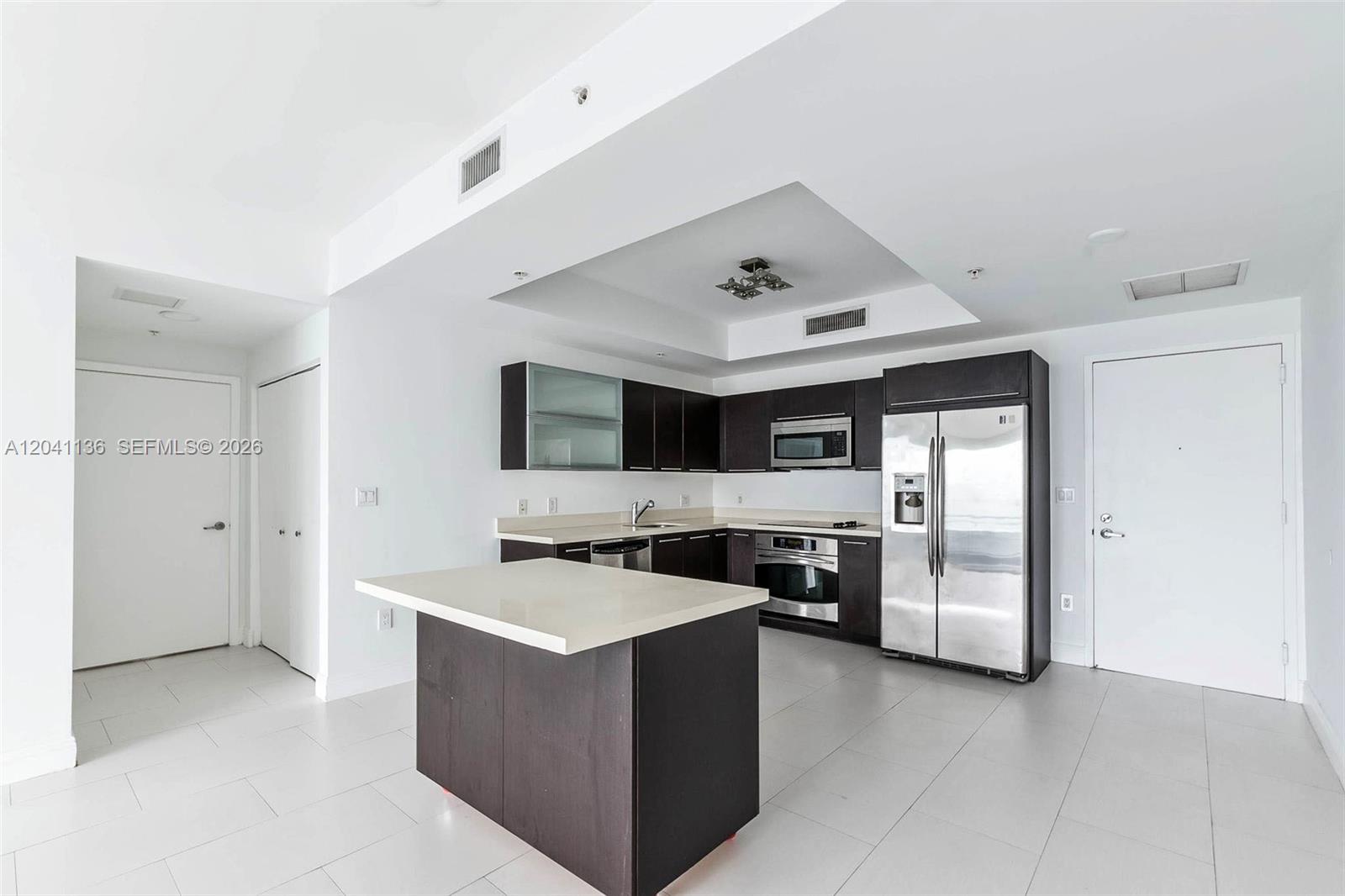 A modern kitchen features dark wood cabinetry, stainless steel appliances, and a central island — 90 SW 3rd St # 3211, Miami FL 33130, MIAMI, FL