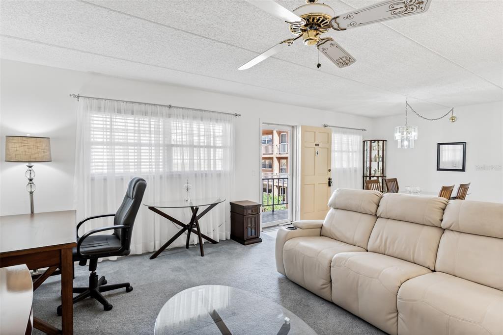 A living room features a white leather sofa, a desk, a ceiling fan, and a balcony — 12760 INDIAN ROCKS ROAD UNIT 546, LARGO, FL
