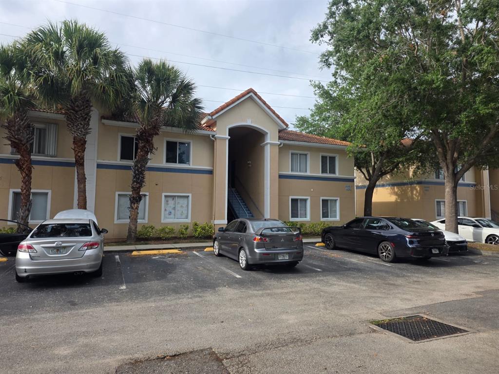 A two-story apartment building with a central breezeway and a parking lot in front — 489 LAS CORTES LANE UNIT 204, ORLANDO, FL