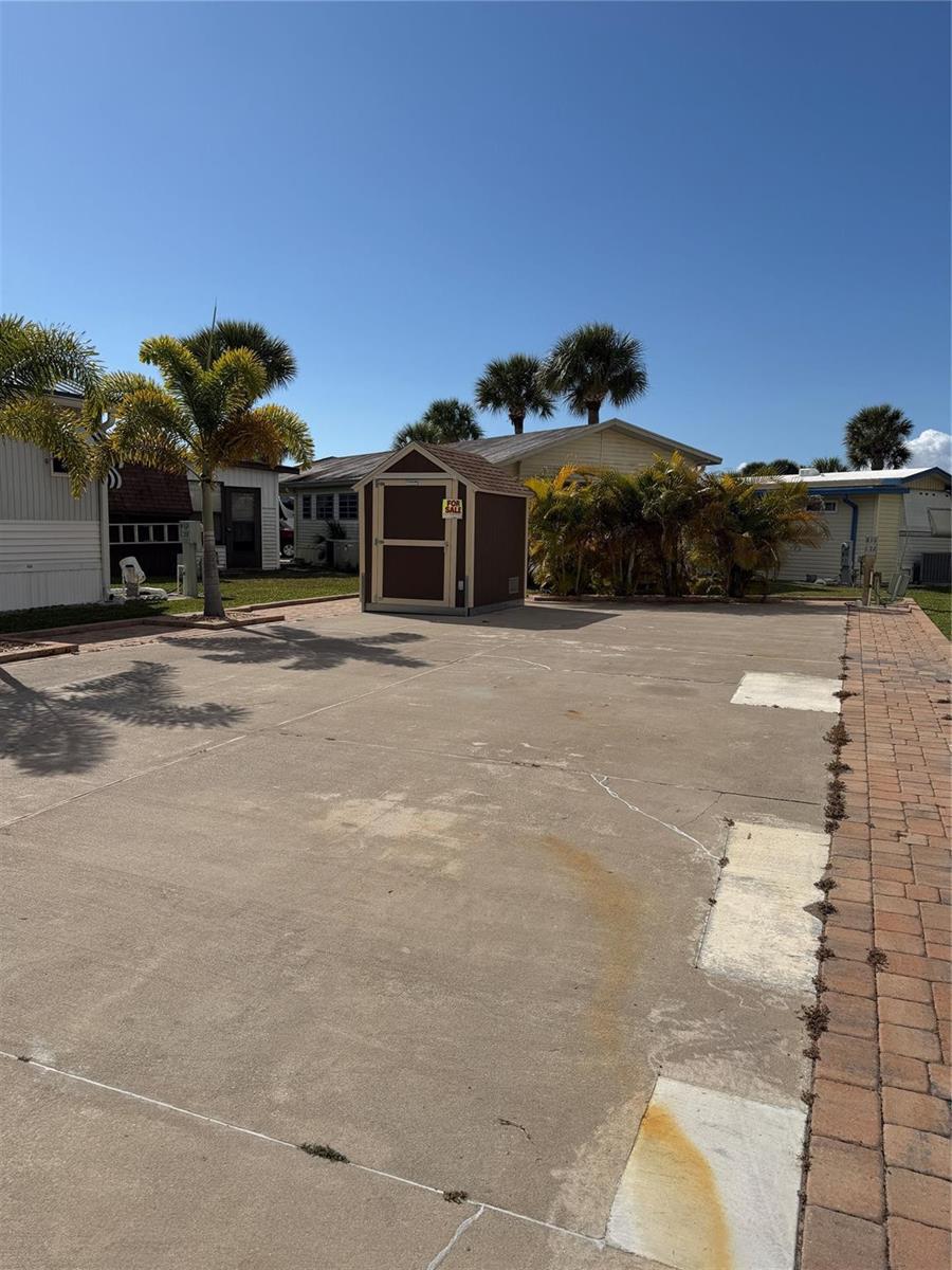 A brown storage shed sits on a large concrete driveway in a mobile home park — 6614 SE 53rd Lane, Okeechobee FL 34974, OKEECHOBEE, FL