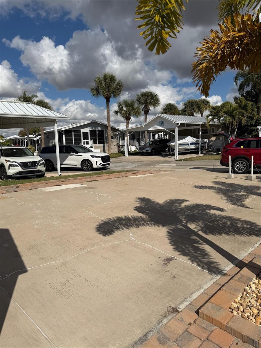 A paved driveway leads to two manufactured homes with carports and palm trees — 6614 SE 53rd Lane, Okeechobee FL 34974, OKEECHOBEE, FL